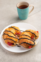 fresh croissant on the table, with hot tea, strawberries and bananas, delicious breakfast