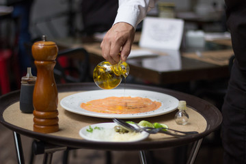 Virtiendo aceite de oliva sobre carpaccio 