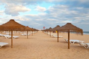 Portugal. Algarve. Beautiful Vilamoura Beach with umbrellas and sunbeds on the sandy shore