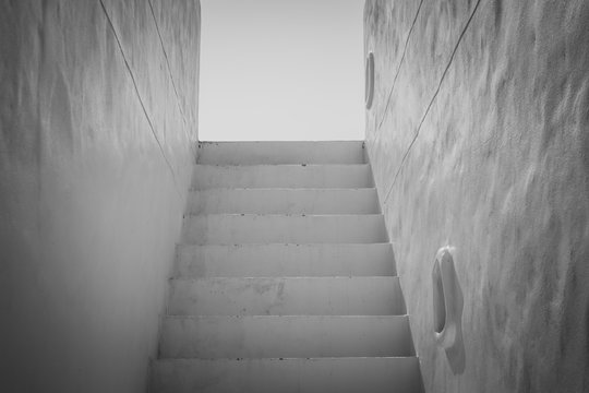 Abstract Black and White image Architecture of white concrete staircase flanked with wall at outside of building. Selective focus