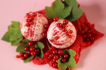 bath bomb with berries extract.red striped bomb for a bath set and red currant berries on a pink background.  berry body cosmetics