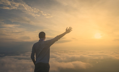 Fototapeta premium Asian men Travel Holiday Relaxation Concept , Vintage Style,sunrise clouds on top of mountain with misty.enjoying beautiful cloudscape.open arm