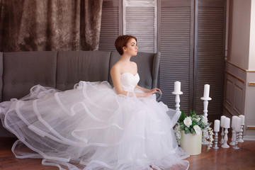 Beautiful young bride in a white dress with beautiful decorations in  studio