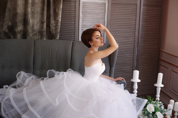 Beautiful young bride in a white dress with beautiful decorations in  studio