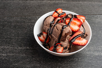 chocolate ice cream with strawberries on a dark background. summer mood, delicious dessert, flat lay