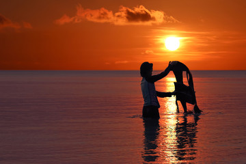 Asian girl enjoying with life jacket  on the beach at sunset, Red sky background at Archipelago island