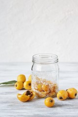compote or syrup from a loquat in a glass jar. Preparation of a syrup from a loquat with sugar. canning fruit.