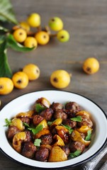 with a loquat dish. Meatballs with a loquat. or mini kebabs. medlar fruit with meatballs. Soft focus. Place for text. Copy Space