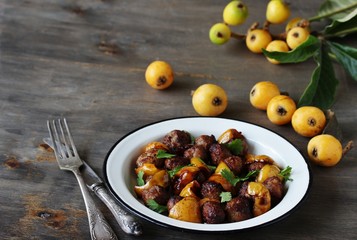 with a loquat dish. Meatballs with a loquat. or mini kebabs. medlar fruit with meatballs. Soft focus. Place for text. Copy Space