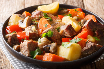 ragout of pork with mushrooms and vegetables close-up on a plate. horizontal