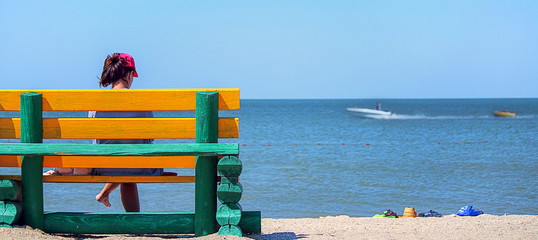 Bench for relaxing on the beach. Against the backdrop of the sea landscape. The concept of rest, relaxation. Selective focus. Banner