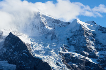 Fototapeta na wymiar Mountain panorama with Jungfrau peak in the clouds in Lauterbrunnen in Switzerland.