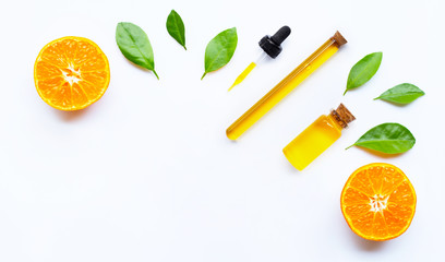 Essential oil with oranges on white.
