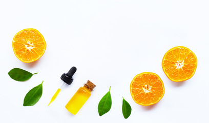 Essential oil with oranges on white.