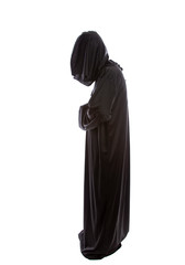 Monk wearing black robes and a hood or a person in a halloween costume of a grim reaper ghost.  The...