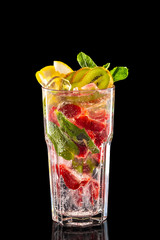 Glass of raspberry, kiwi and lemon ice lemonade isolated on black background