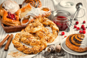  Sand pretzels, bun with poppy seeds on a table with fruits