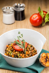 Stewed beans with vegetables on a white plate