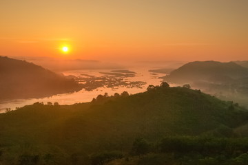 sunrise at Phu Huay Esan View Point, view of the hill around with sea of mist above Mekong river with red sun light in the sky background, Ban Muang, Sang Khom District, Nong Khai, Thailand.