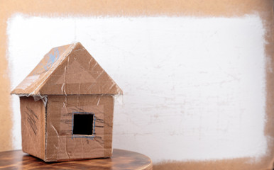 Obraz na płótnie Canvas Handmade cardboard house on dirty white textured background.