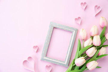 Happy mothers day concept. pink tulip flower with paper heart and Picture Frame with Happy mother's day text on pink pastel background.