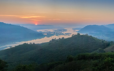 Fototapeta na wymiar sunrise at Phu Huay Esan View Point, view of the hill around with sea of mist above Mekong river with soft red sun light in the sky background, Ban Muang, Sang Khom District, Nong Khai, Thailand.