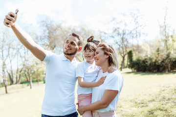 Family with child takes a selfie photo.
