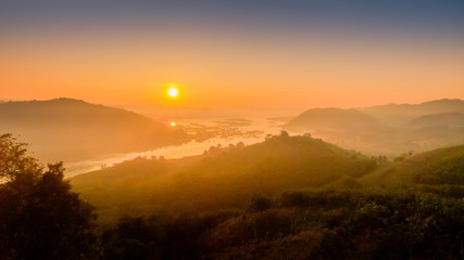 Fototapeta na wymiar sunrise at Phu Huay Esan View Point, view of the hill around with sea of mist above Mekong river with red sun light in the sky background, Ban Muang, Sang Khom District, Nong Khai, Thailand.