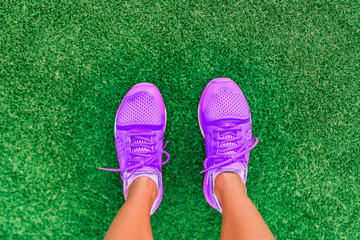 Fitness lifestyle active girl top view of running shoes woman standing on grass. pov selfie of feet...