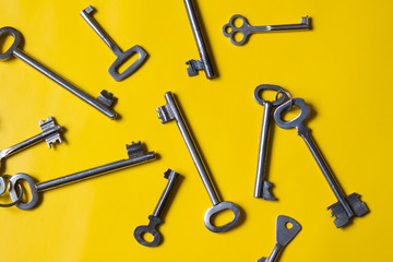 Old keys on yellow background. Top view.