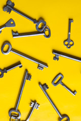 Old keys on yellow background. Top view.