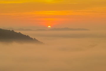 Fototapeta na wymiar sunrise at Phu Huay Esan View Point, view of the hill around with sea of mist above Mekong river with red sun light in the sky background, Ban Muang, Sang Khom District, Nong Khai, Thailand.