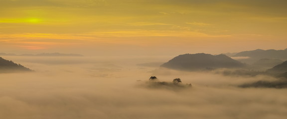 sunrise at Phu Huay Isan View Point, view of the hill around with sea of mist above Mekong river with yellow sun light in the sky background, Ban Muang, Sang Khom District, Nong Khai, Thailand.