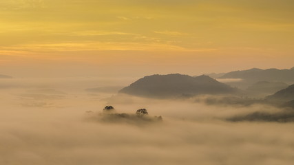 sunrise at Phu Huay Isan View Point, view of the hill around with sea of mist above Mekong river with yellow sun light in the sky background, Ban Muang, Sang Khom District, Nong Khai, Thailand.