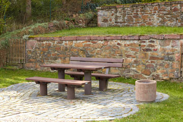A table with benches for rest. Resting place in nature. The forest rest area is made of wood. Table and bench for people in nature.