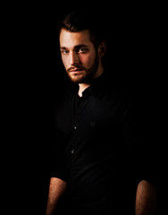 Fototapeta premium stylish man with a beard in a black shirt on a black background