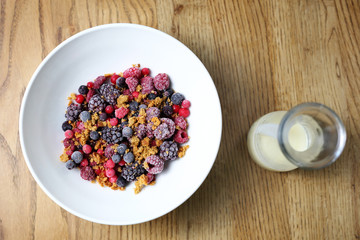 Frozen fruits with granola and yogurt, healthy fruit breakfast.
