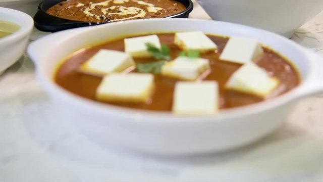 Indian vegetarian  platter / Thali having Palak paneer butter masala, dal makhani, flat bread or naan and rice served in a white plate