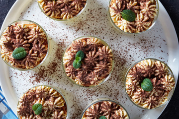 classic tiramisu, italian dessert in round glasses