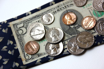 American coins on dollar note with blue necktie isolate on white background ,selective focus .money for saving.