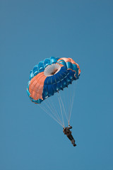 Parachute against the blue sky in an unusual color scheme. Imitation of a two-color film process.