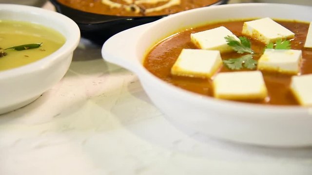 Indian vegetarian  platter / Thali having Palak paneer butter masala, dal makhani, flat bread or naan and rice served in a white plate