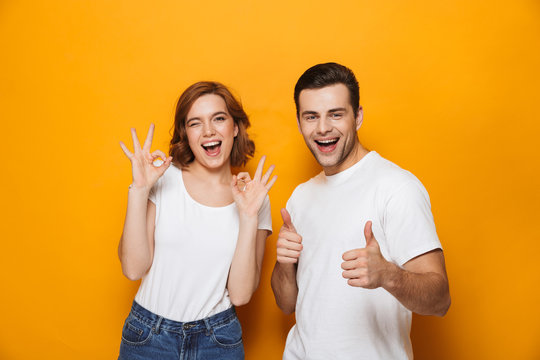 Excited beautiful couple wearing white t-shirts standing