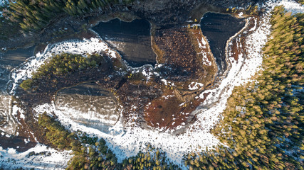 Aerial view on wild nature rural forest with lake and snow melting in spring