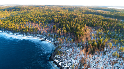 Aerial view on river with melting ice, sunny spring weather with snow.