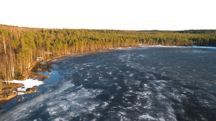Aerial view on river with melting ice, sunny spring weather with snow.