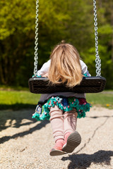 Kind spiel auf Spielpatz mit Schaukel. Girl playing on playground with swing.