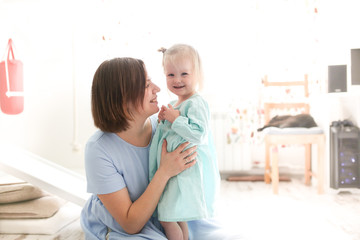 cute girl hugs mom, daughter toddler blonde