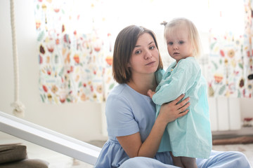 cute girl hugs mom, daughter toddler blonde