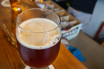 Cold glass of craft beer on wooden table.